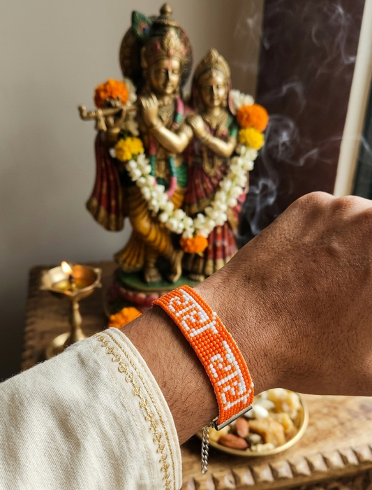 Hand-Woven "Radhe Radhe" Beaded Bracelet in Saffron & White