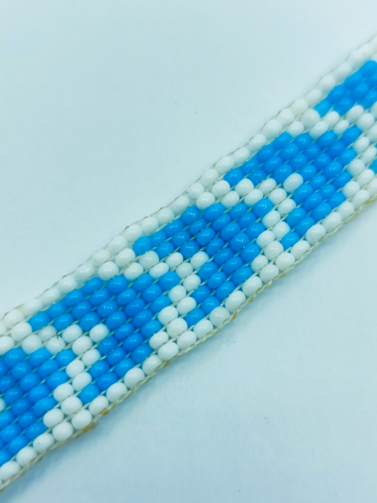 Handcrafted blue and white geometric seed bead loom bracelet with silver adjustable chain