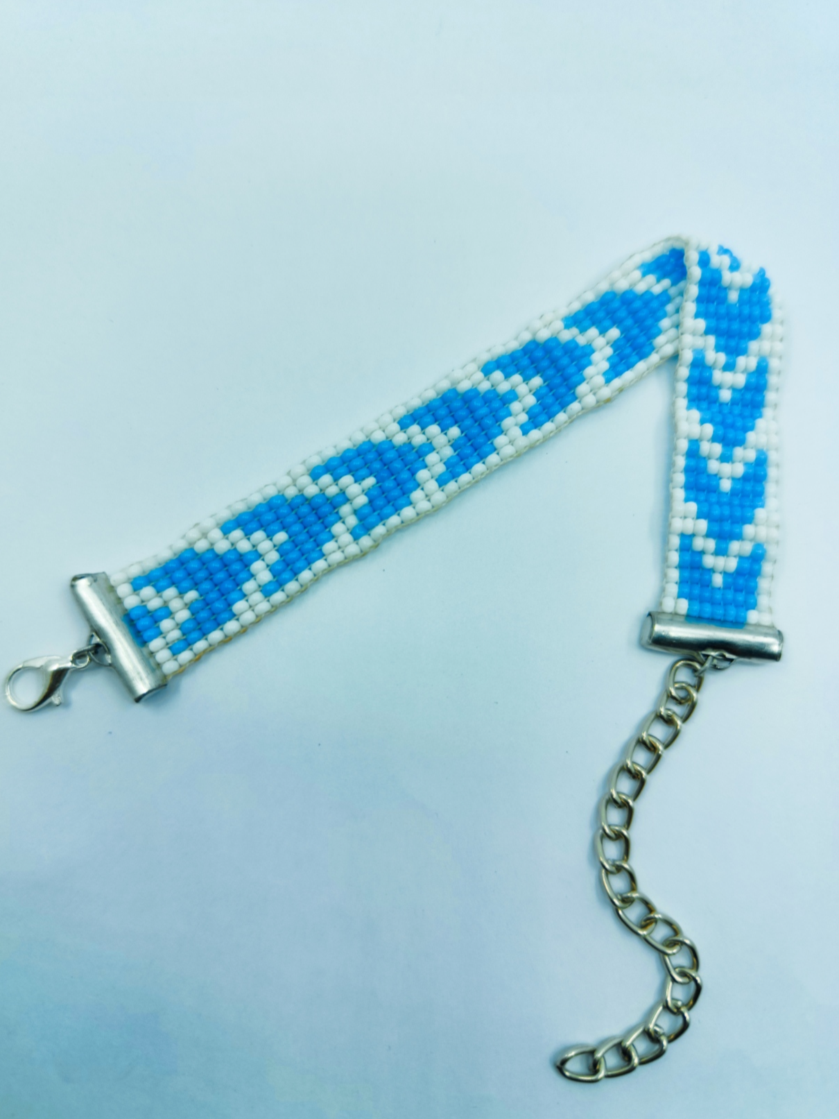 Handcrafted blue and white geometric seed bead loom bracelet with silver adjustable chain